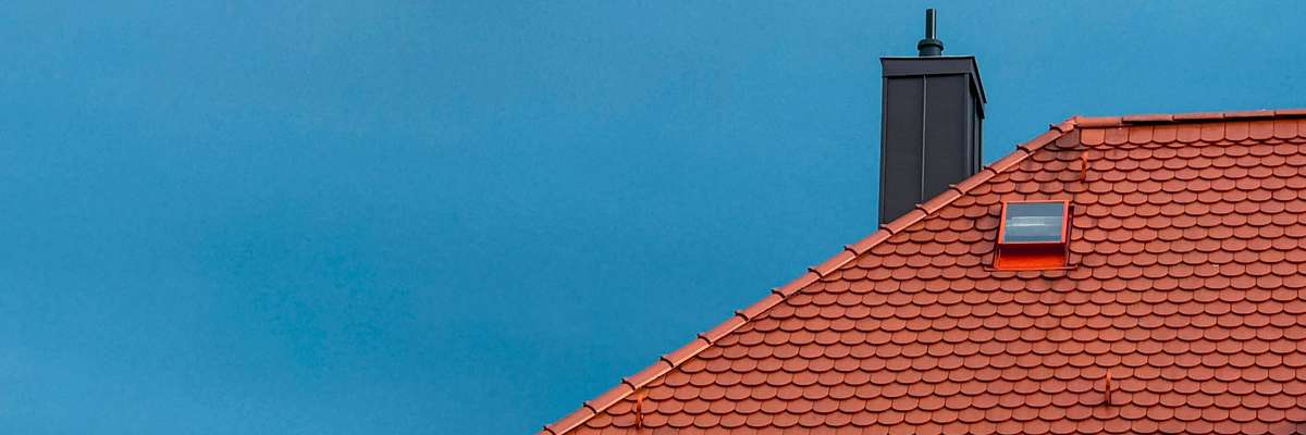 A residential rooftop viewed from above, showing architectural shingles in good condition.