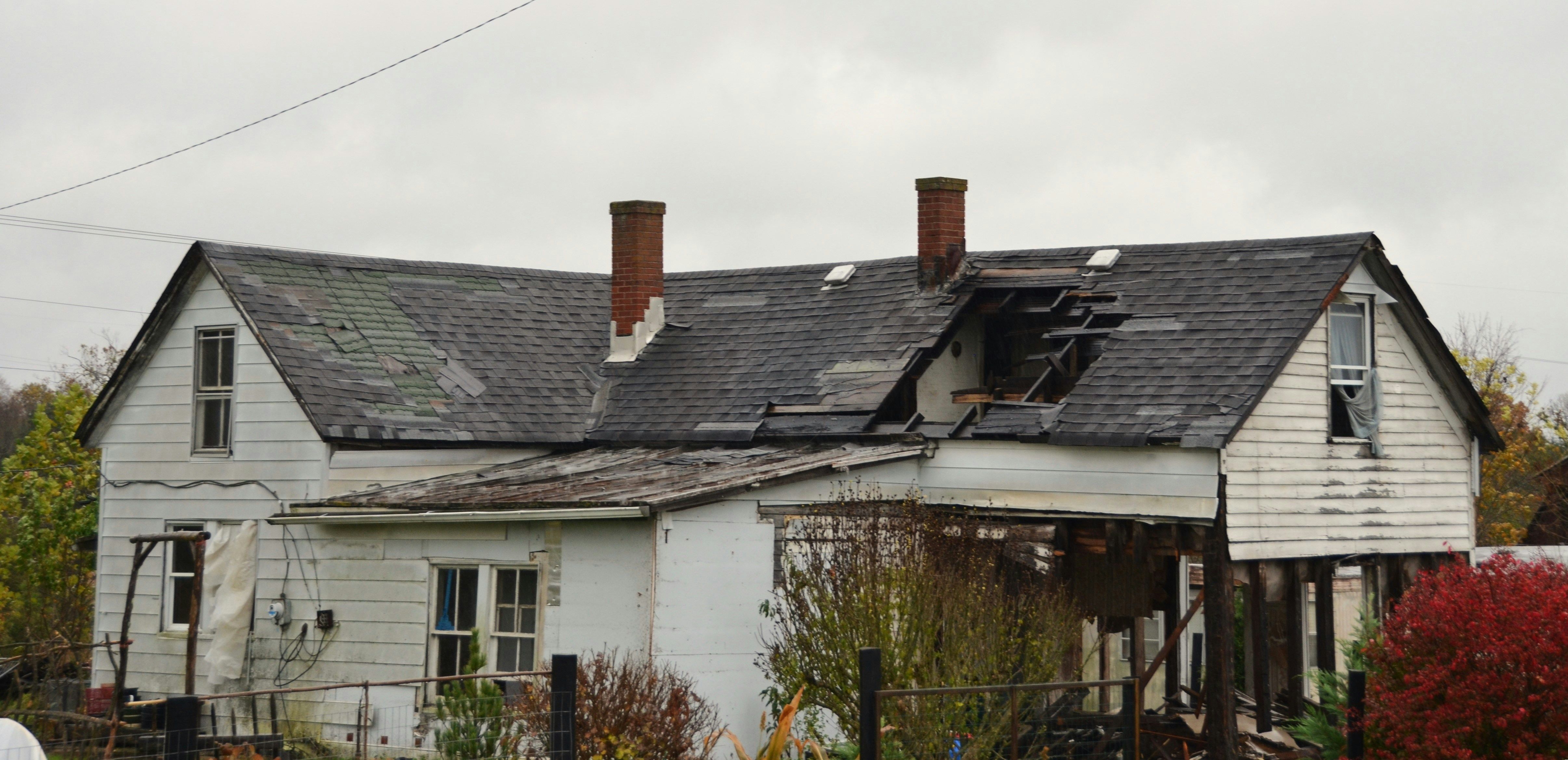 Storm-damaged roof with missing and lifted shingles
