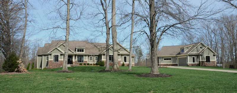 Craftsman-style home with attached garage on a wooded lot