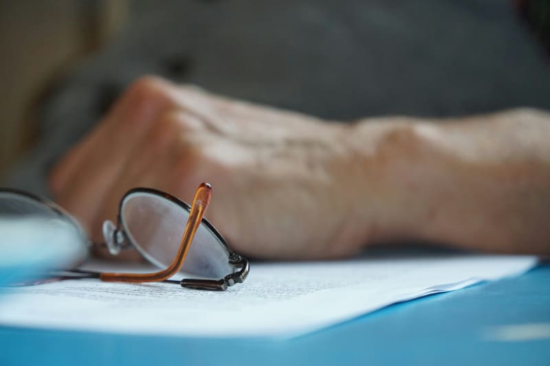 Reading glasses resting on printed documents