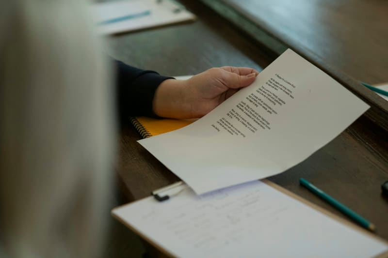 Hand holding a printed letter at a desk