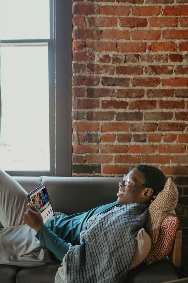 Homeowner sitting on a couch reading insurance documents