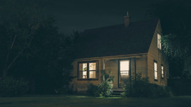 Small house at night with lit windows
