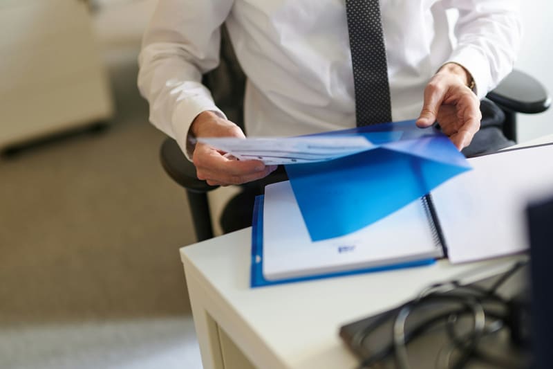 Person in office holding a blue document folder