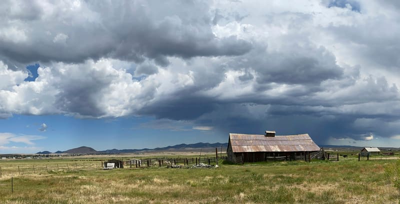 Rusty metal roof barn under storm clouds