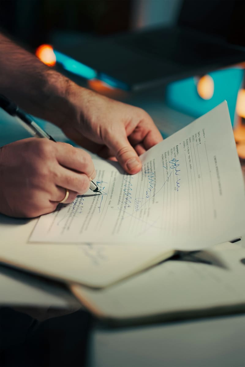 Hands signing a contract, close-up