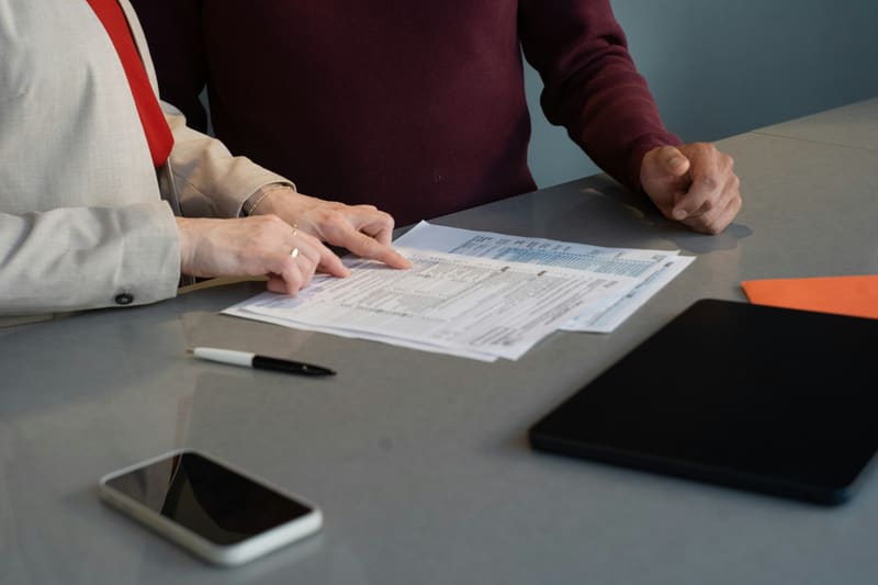 Two people reviewing insurance forms at a desk